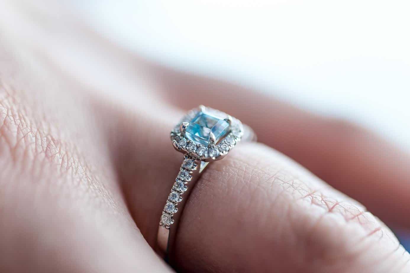 person showing silver-colored ring with gemstone